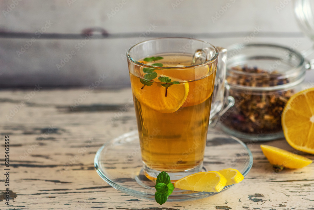 Cup of Lemon tea with lemon slices and mint on light wooden table. With Copy Space Cup of Lemon tea with lemon slices and mint on light wooden table. With Copy Space