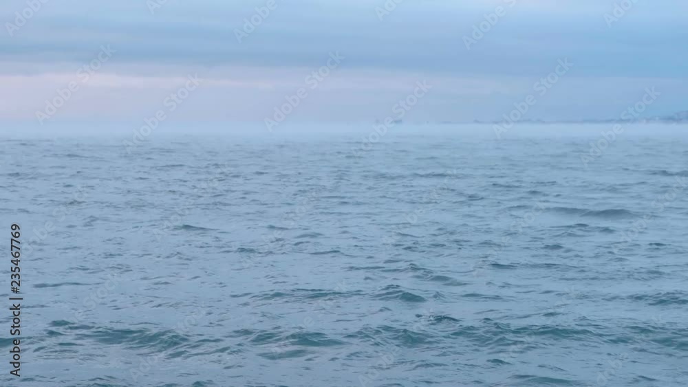 Mist and fog over the sea. Beautiful seascape with pink sunset and blue clouds. Calm sea. Mist and fog over the sea. Beautiful seascape with pink sunset and blue clouds. Calm sea.