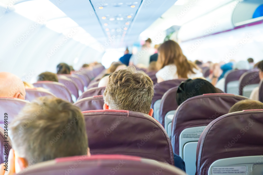 Naklejka premium Passengers sit inside airplane - people traveling