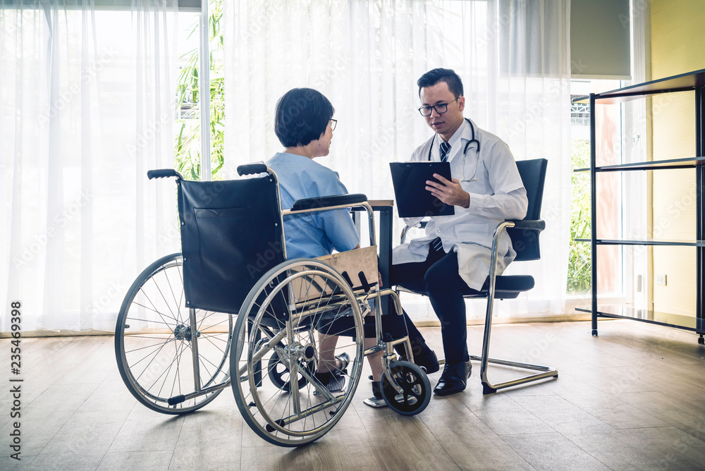 Doctor talking to senior women in wheelchair after check Doctor talking to senior women in wheelchair after check