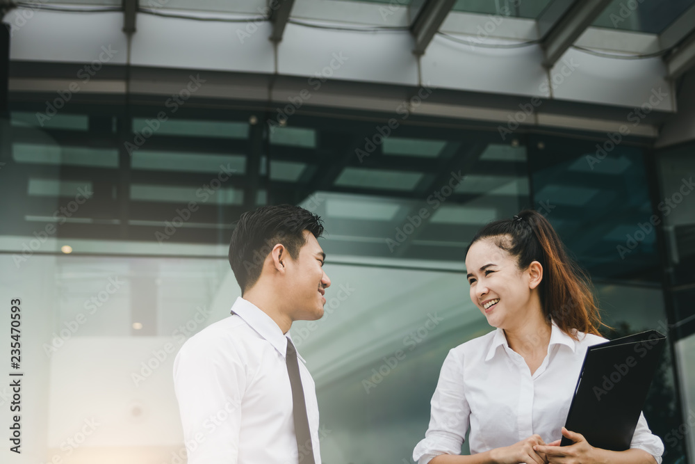 Two business people talking together at office building. Two business people talking together at office building.