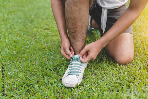 Young asian man prepare shoe before running in the morning,Exercise and healthy concept, Selective focus.