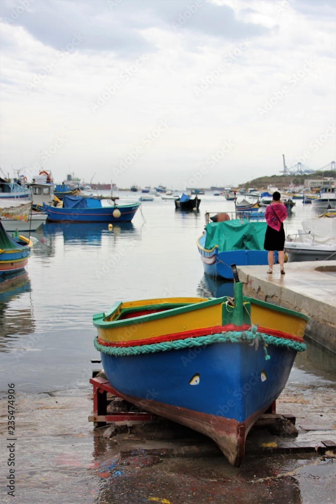 Malta august 2015 Marsaxalok lonely woman on the dock