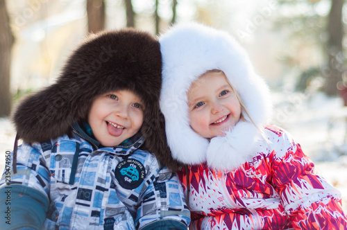 Beautiful children in winter in fur hats. Laugh and rejoice.