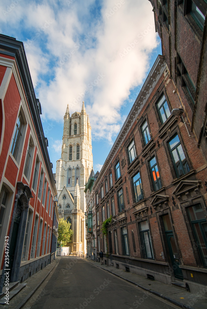 Beautiful narrow street of Ghent city, view to the Saint Bavo Cathedral