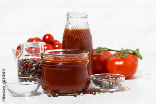 Products made with fresh tomato - sauce, juice and seasonings on white table