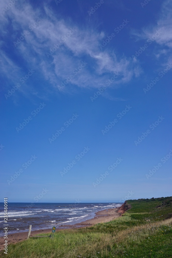 Prince Edward Island, Canada: A red sandstone beach under a clear blue sky on the north shore of Prince Edward Island, in the Gulf of St. Lawrence.
