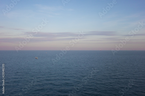 Blue ocean and sky with pastel clouds