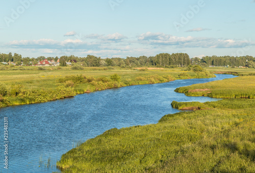 River with green banks on a sunny summer day