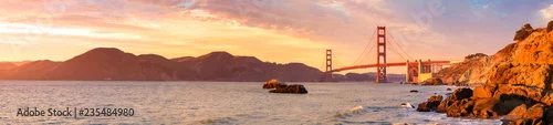 Obraz  z motywem Panoramic view of famous Golden Gate Bridge seen from Baker Beach in beautiful golden evening light. San Francisco, California, USA