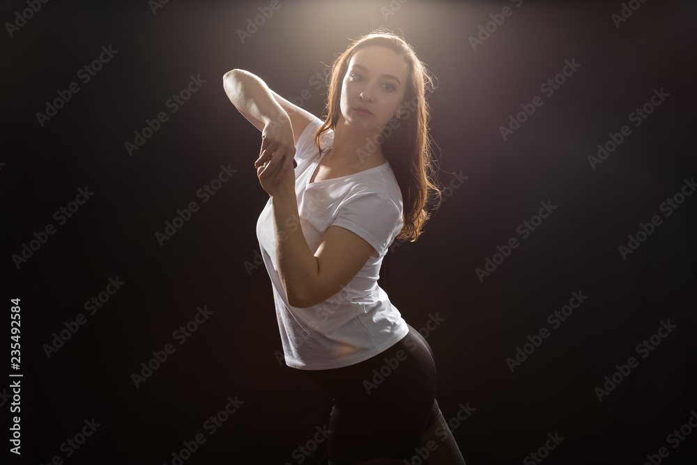 Young woman jazz funk dancer exercising dance moves in studio