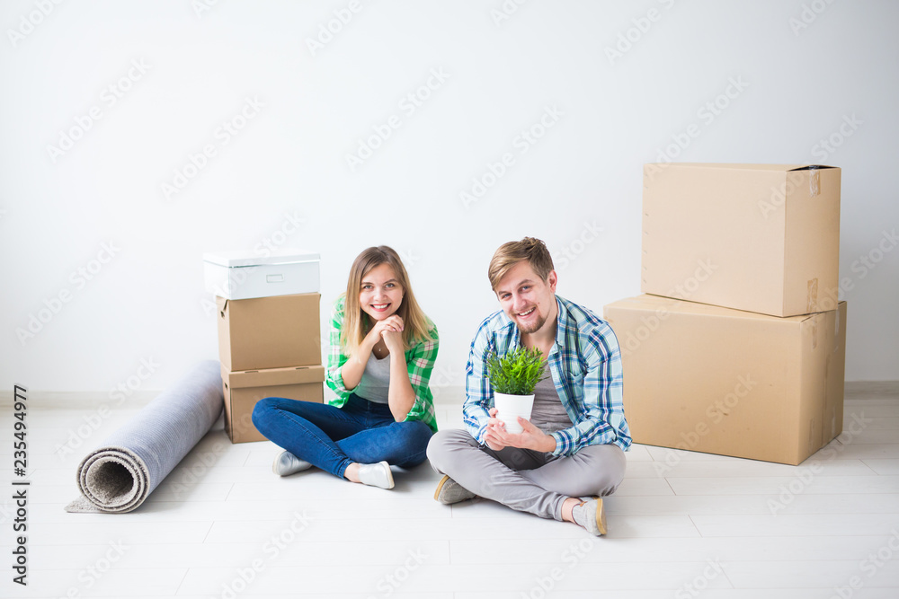 Relocation, real estate and moving concept - Young cheerful couple moving into their new home Relocation, real estate and moving concept - Young cheerful couple moving into their new home