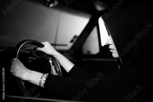 Portrait of hipster girl who driving car in night. Black and white photo.