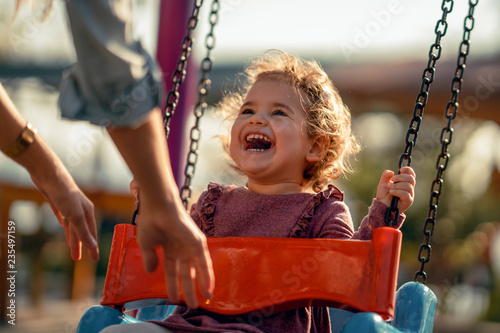 Adorable little girl having fun on a swing photo