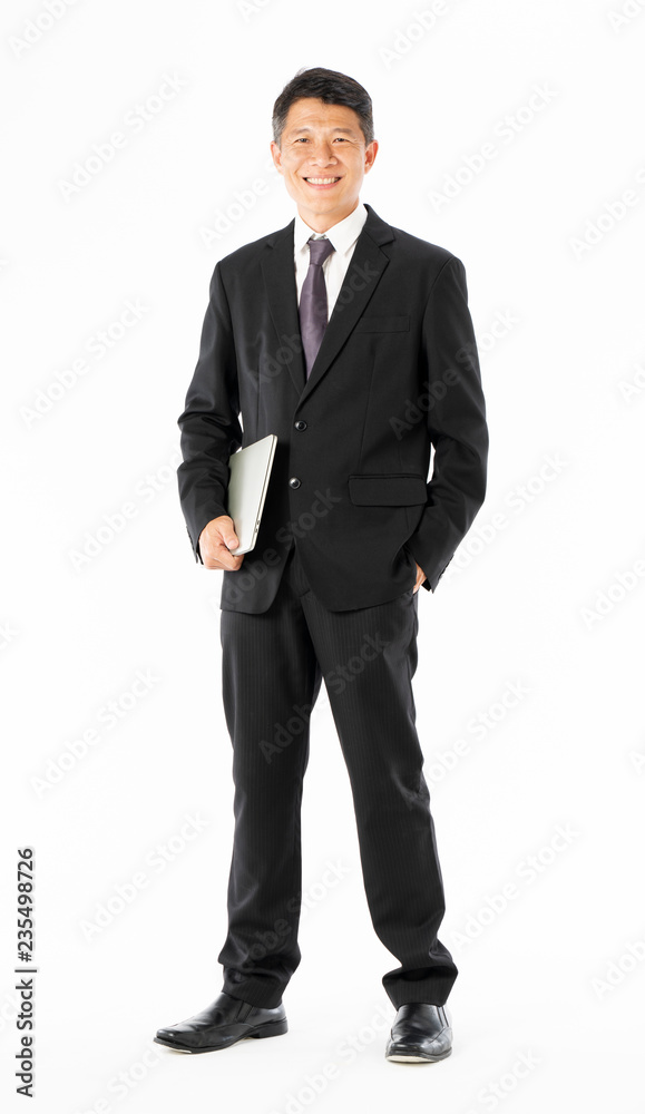 Business man in black suit standing and holding laptop Business man in black suit standing and holding laptop