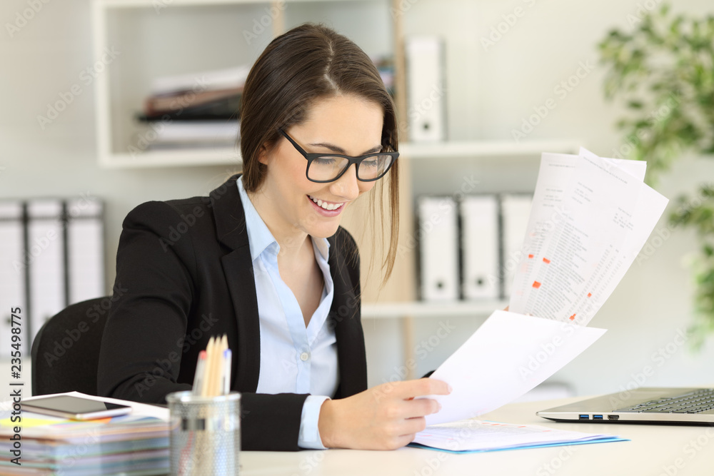 Happy office worker with eyeglasses comparing documents Happy office worker with eyeglasses comparing documents