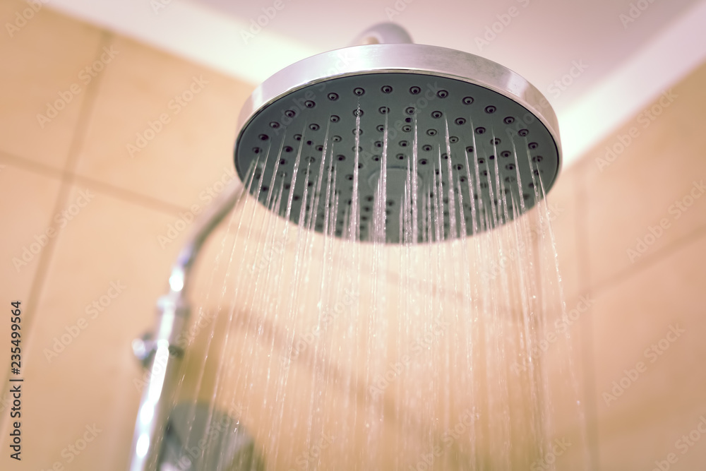 Water running from the shower head in the bathroom, close-up Water running from the shower head in the bathroom, close-up