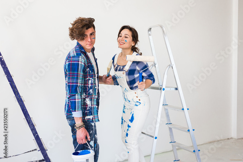 Teamwork and repair concept - young couple doing a renovation in new apartment