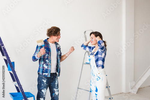 Conflict, repair and renovation concept - Young woman and man with annoying faces and bad emotions during renovation in apartment