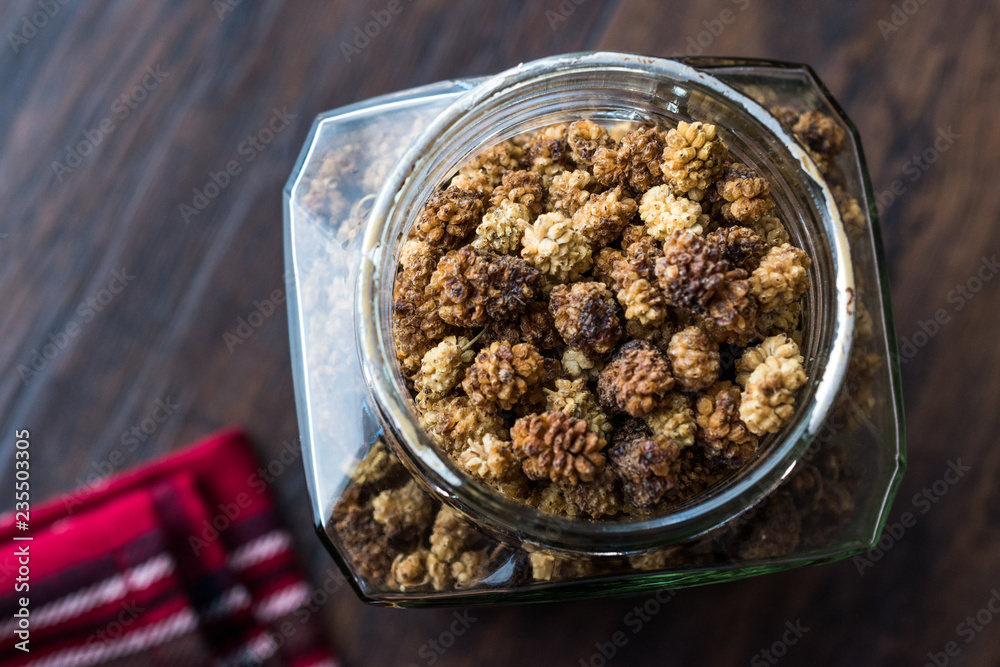 Jar of Dried Mulberries on Dark Wooden Surface. Jar of Dried Mulberries on Dark Wooden Surface.