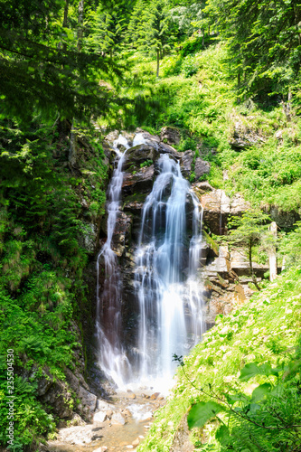 A valley with a waterfall in Mountains near the ski resort in tropical forest. Russian nature near Sochi  Caucasus Mountains.