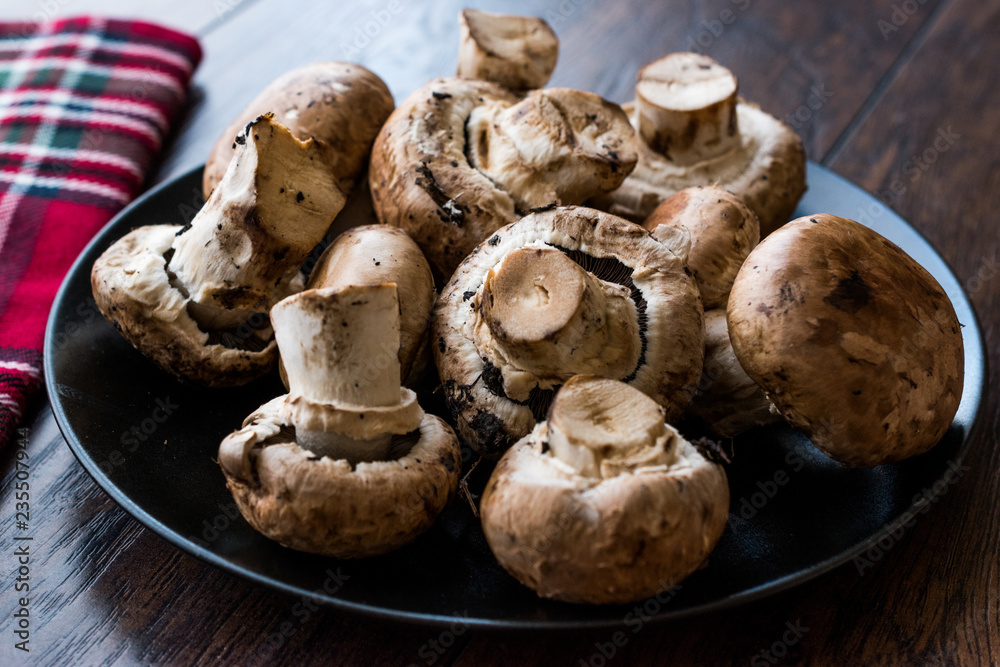 Portobello Raw Cremini Mushrooms in Black Plate. Portobello Raw Cremini Mushrooms in Black Plate.