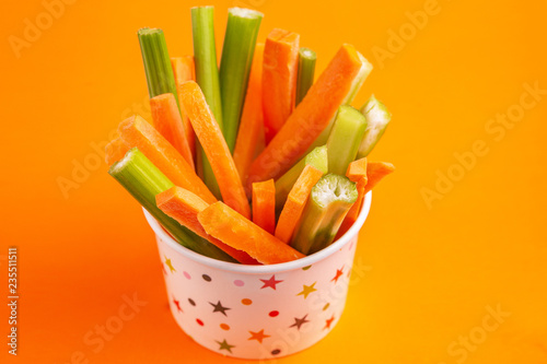 Fresh carrots and celery sticks in paper cup