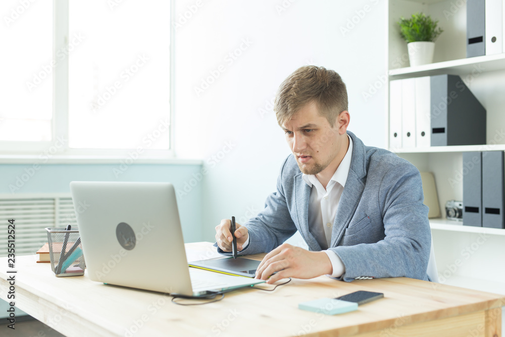 Designer, artist and web design concept - Portrait of young man using digital pen tablet and laptop in the office Designer, artist and web design concept - Portrait of young man using digital pen tablet and laptop in the office