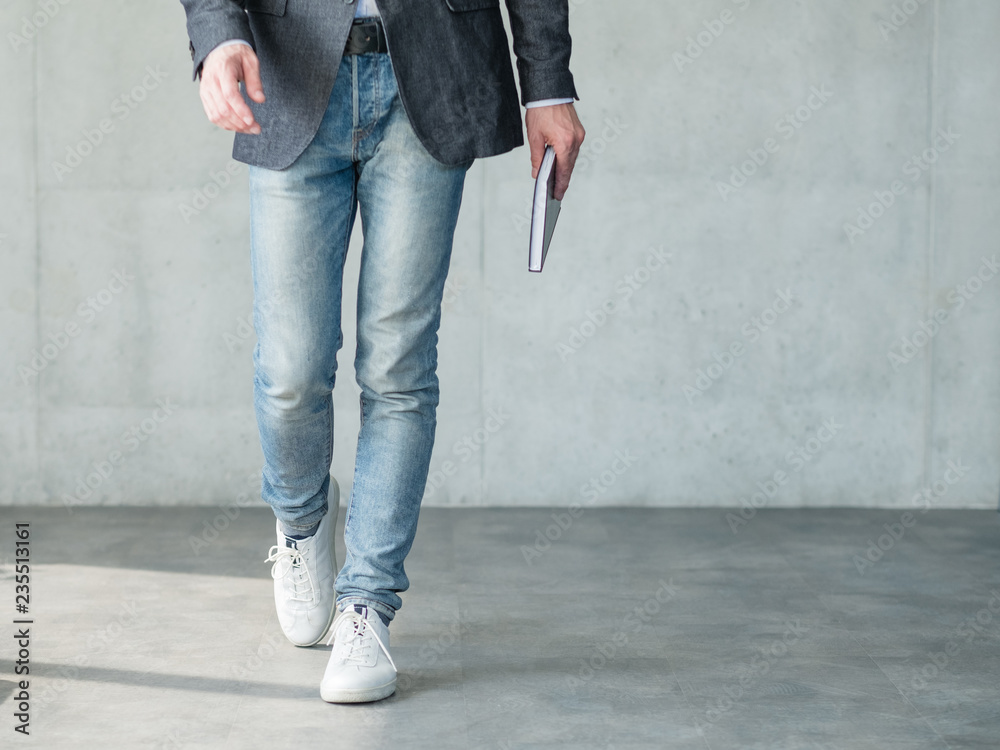 business man walking holding notebook in hand. smart casual fashion style business man walking holding notebook in hand. smart casual fashion style