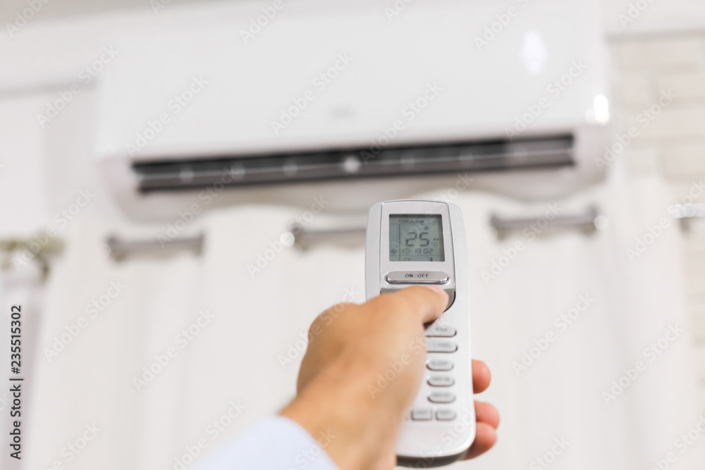 hand holds a remote control of air conditioner hand holds a remote control of air conditioner