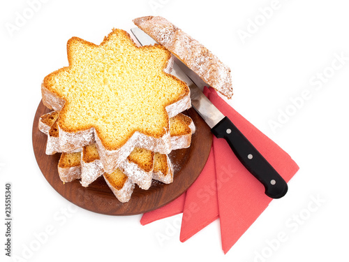 Sliced pandoro, Italian sweet yeast bread, traditional Christmas treat. With red serviettes and knife on white. Overhead flat lay view. photo