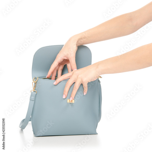 Woman's female blue leather bag in hand pulls out of the bag on white background isolation