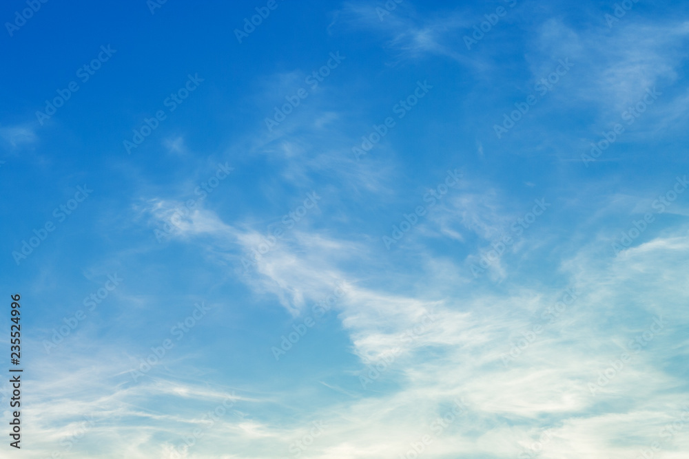 White cirrus clouds in bright blue sky (background)