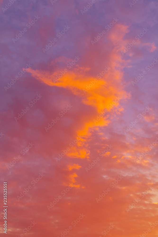 Dramatic view on a orange clouds in the sunset sky (background, toned)