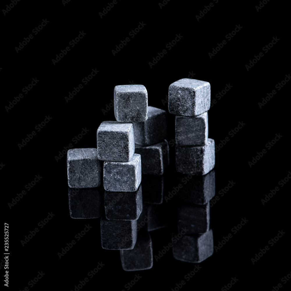 Whisky stones on black background, with reflection. Soapstone for chilling whisky Whisky stones on black background, with reflection. Soapstone for chilling whisky
