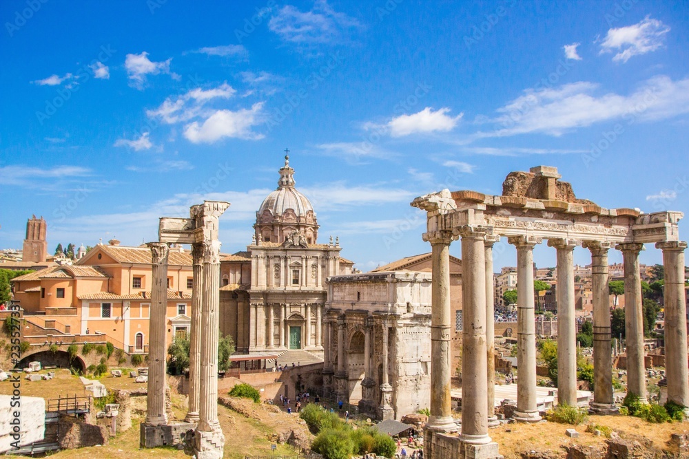 Ruins of the Roman Forum. Overview of the ancient Forum: temples, pillars, senate, Temple of Saturn, Arch of Septimius Severus, the church of Santi Luca e Martina. Rome, Italy.