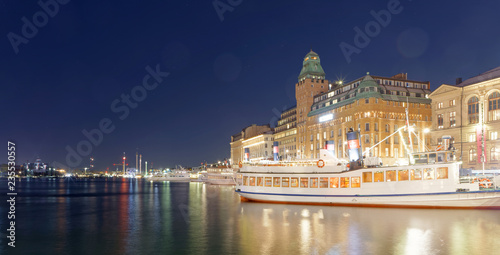 Ferries at the quay, old buildings and colors reflecting in the sea at night photo