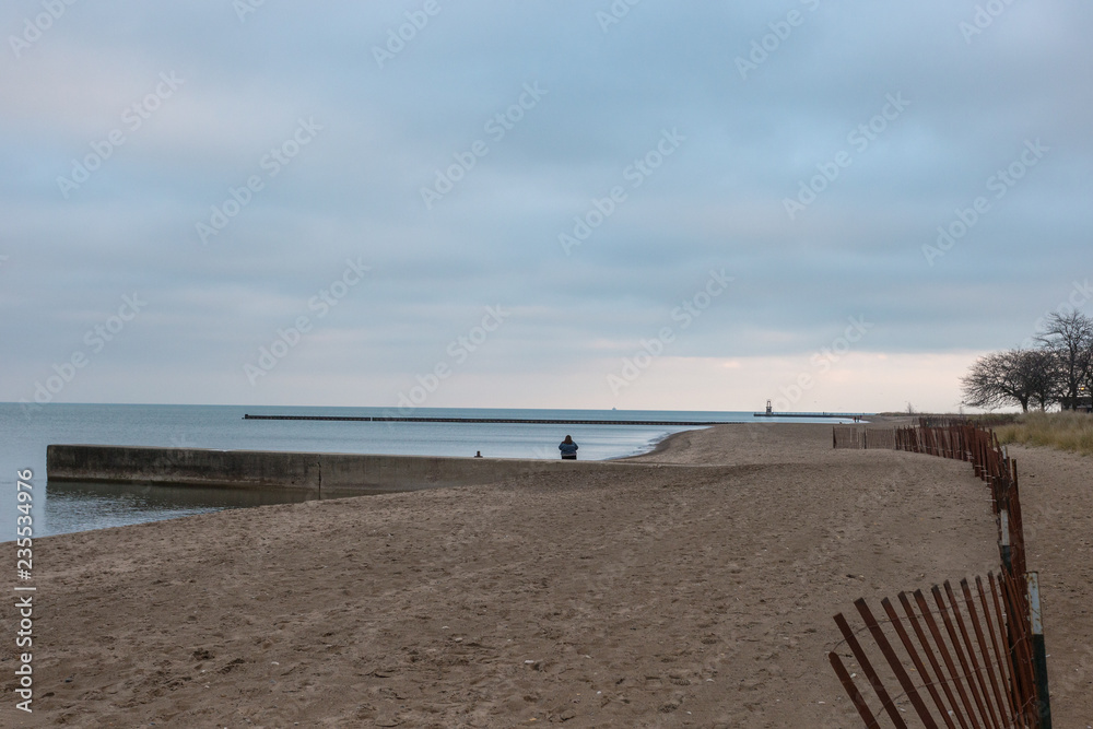 Lonely person on beach at sunset