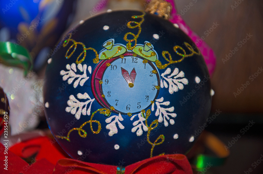 Christmas toy. Clock on a blue background and golden spiral lines.