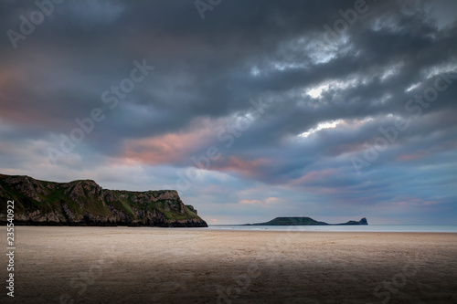 Sunset clouds at Rhossili Bay and Worms Head on the Gower peninsula, Swansea, South Wales, UK photo