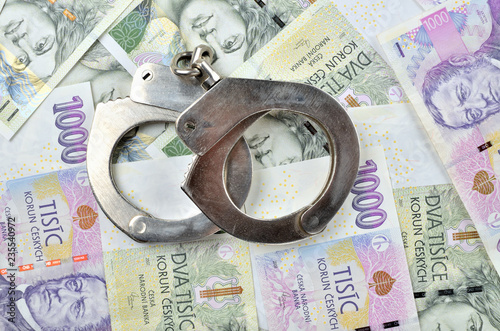 Police handcuffs on Czech banknotes, czech crown money CZK - the concept of finance and crime