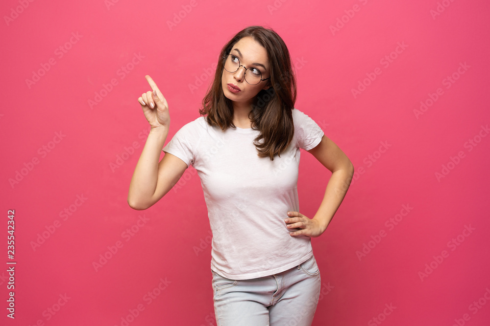 Photo of happy young woman standing isolated over pink background. Looking camera showing copyspace pointing. Photo of happy young woman standing isolated over pink background. Looking camera showing copyspace pointing.