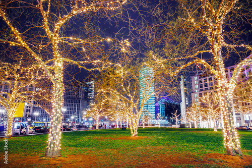 Ornamented illuminated trees on Potsdamer Platz in Berlin, Germany. Christmas time in Berlin. December winter holidays background.