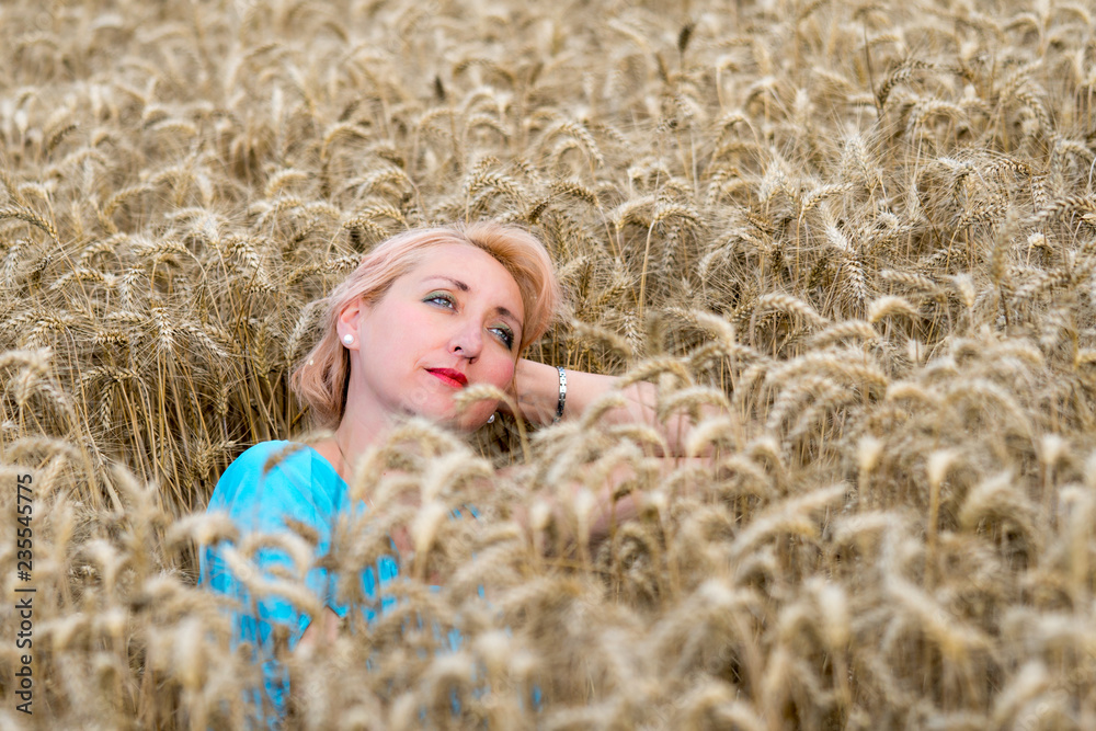 Portrait of beautiful woman with green eyes sitting in golden wheat field and look in the sky. Liberty, love, happy summer, peace of mind or relaxation concept. Portrait of beautiful woman with green eyes sitting in golden wheat field and look in the sky. Liberty, love, happy summer, peace of mind or relaxation concept.