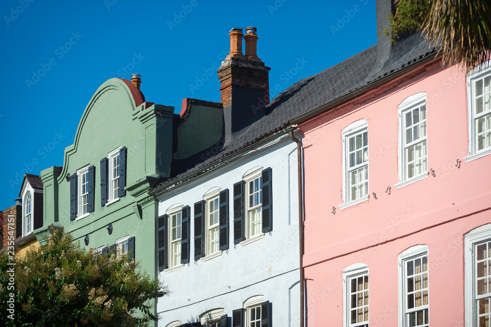 Obraz premium Brightly colored colonial architecture lining the historical Battery neighborhood under blue sky in Charleston, South Carolina, USA