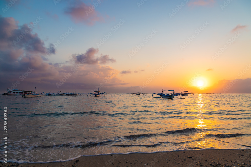 Beautiful sunrise at Sanur Beach, Bali. Traditional fishing boat on seashore at colorful sunrise. Indonesia. Beautiful sunrise at Sanur Beach, Bali. Traditional fishing boat on seashore at colorful sunrise. Indonesia.