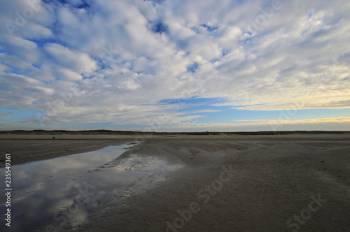 Fototapeta Naklejka Na Ścianę i Meble -  Nadmorskie wybrzeże, plaża i morze pod niebieskim niebem z chmurami.