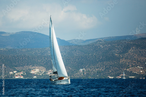 Sailing yacht boat glides on the surface of the Aegean sea near the Greek coast. © De Visu