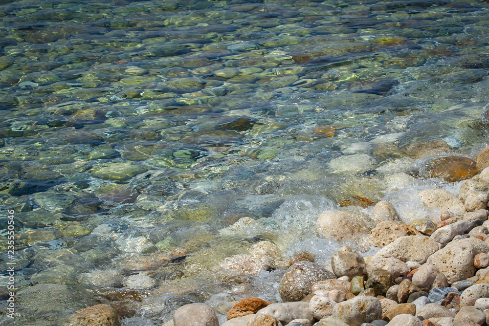 Sea colored stones in the transparent water
