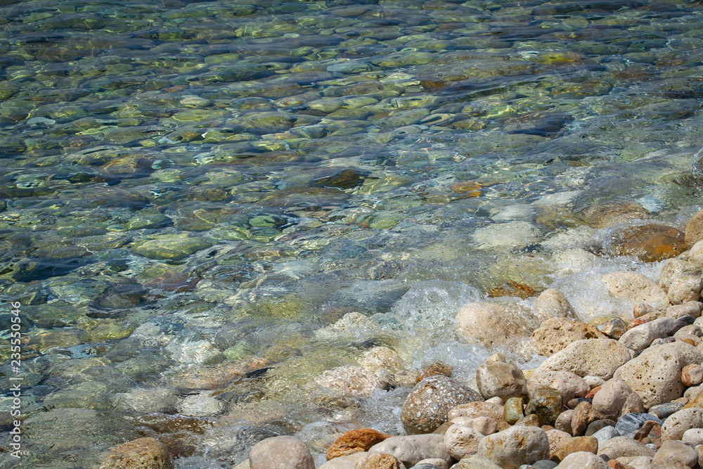 Sea colored stones in the transparent water Sea colored stones in the transparent water